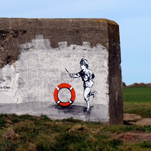 Bunker dans la nature avec street art représentant un enfant jouant avec une bouée - France  - collection de photos clin d'oeil, catégorie rues